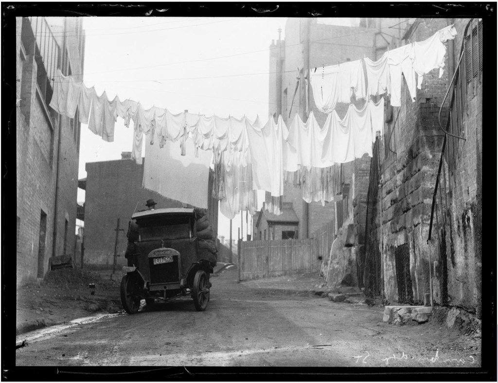 Washing drying on lines between terrace houses in a slum area, Sydney, ca. 1932